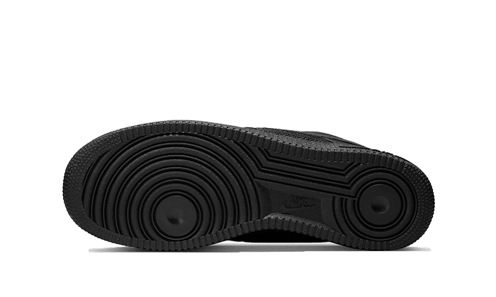 Exclusieve Nike Air Force 1 Low Slam Jam sneakers in zwart tegen een donkergroen oppervlak. Deze iconische lage sneakers hebben een robuuste zool met een opvallend patroon en een gestroomlijnd ontwerp.