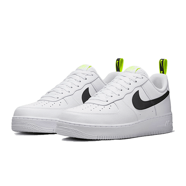 Witte Nike Air Force 1 Low Volt sneakers op een groene achtergrond. Klassieke lage sneaker met zwarte Nike Swoosh-branding en opvallende felle gele accenten. Een functioneel design dat past bij elke stijl.