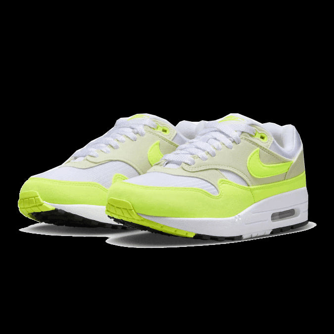 Neon gele Nike Air Max 1 '87 Volt Suede sneakers op een groene achtergrond
