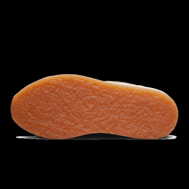Oranje rubberen zool van de Nike Air Max 1 Crepe Light Bone sneaker, duidelijk zichtbaar op de afbeelding.