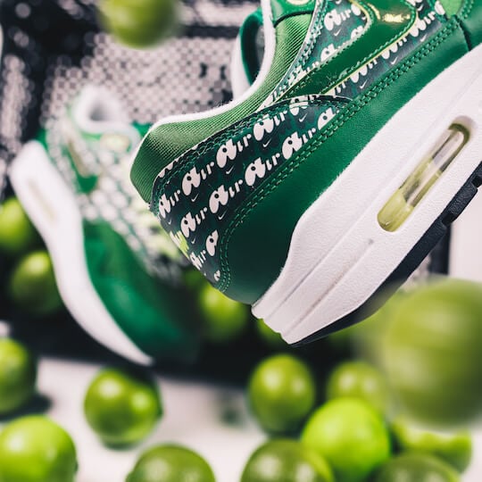 Groene Nike Air Max 1 Limeade (2020) sneakers omgeven door verse citroenen op witte achtergrond