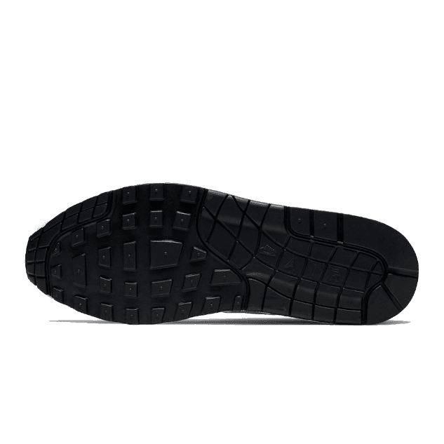 Zwarte Nike Air Max 1-sneakerzool met opvallend patroon tegen een groene achtergrond