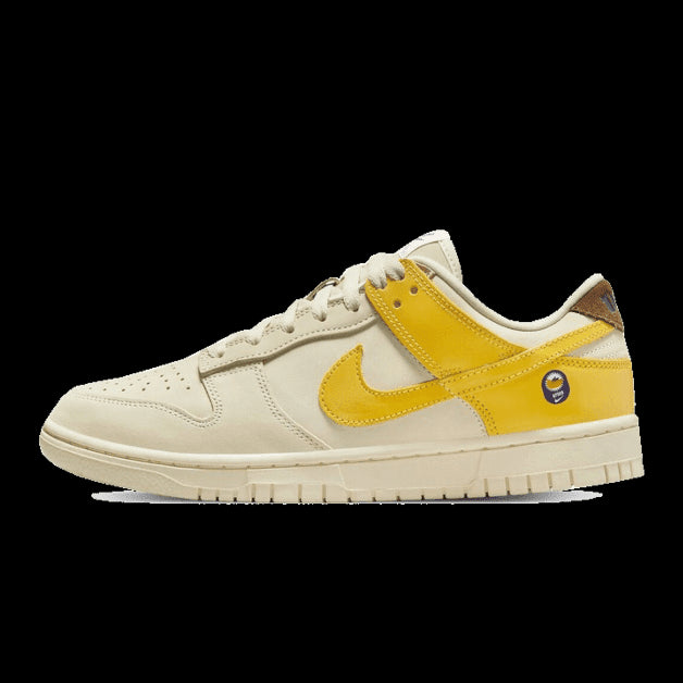 Sneakers Nike Dunk Low Banana in crème en geel, met opvallende gele details op een licht vintage-geïnspireerd ontwerp