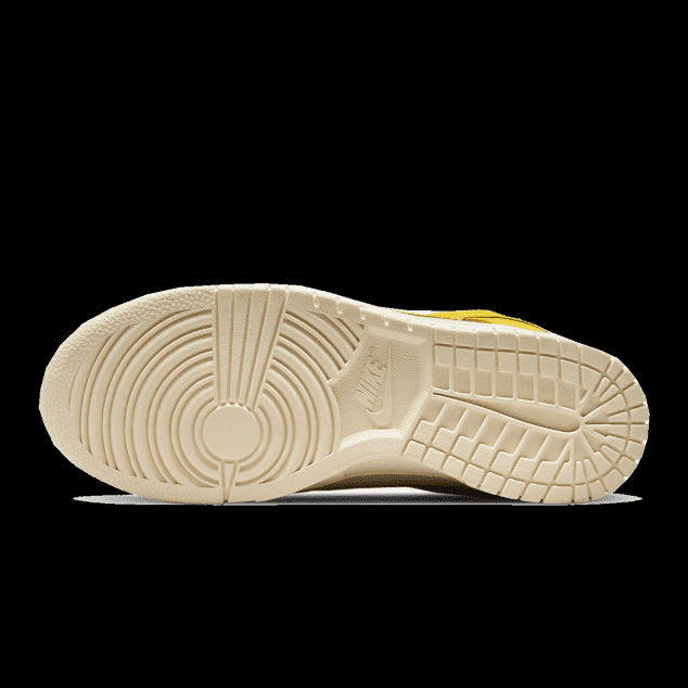 Duurzame Nike Dunk Low Banana sneakers met gele en zandkleurige accenten op een stevige, geribbelde rubberen zool.