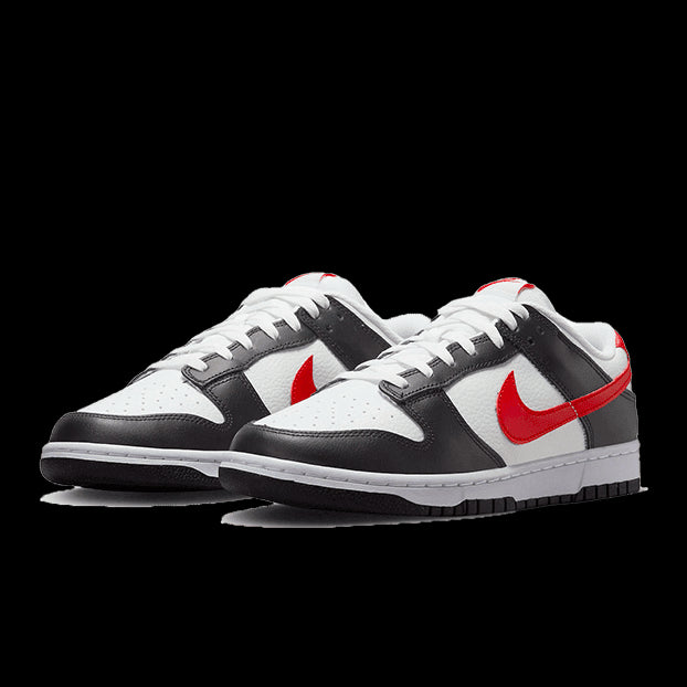 Trendy Nike Dunk Low sneakers in een stijlvolle combinatie van zwart, wit en rood, geplaatst op een gekleurde achtergrond.