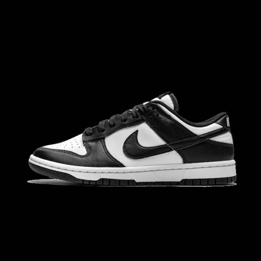 Zwarte en witte Nike Dunk Low sneakers op neutrale achtergrond. De iconische Nike Swoosh-logo is prominent zichtbaar op de zijkanten van de schoen. Deze klassieke sneakers kenmerken zich door een lichtgewicht, goed ondersteunend ontwerp.