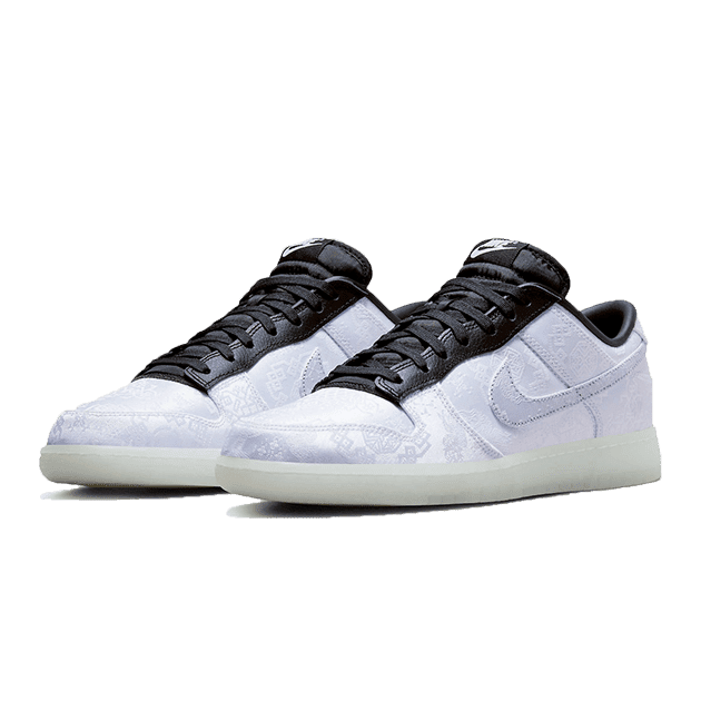 Unieke witte Nike Dunk Low CLOT Fragment sneakers op een groene achtergrond. Deze iconische sneakers combineren elegantie en sportiviteit met hun minimalistisch ontwerp en contrasterende zwarte en witte kleuren.