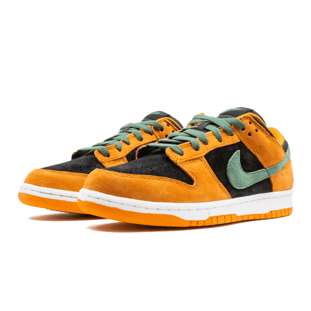 Oranje en zwarte Nike Dunk Low Ceramic (2020) sneakers tegen groene achtergrond