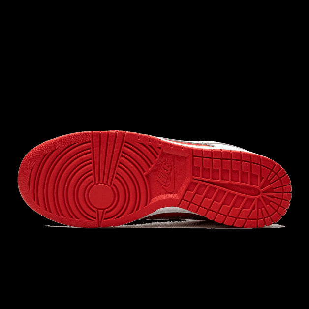 Rode Nike Dunk Low Championship sneakers met een opvallend gestreept zoolpatroon op een groene achtergrond