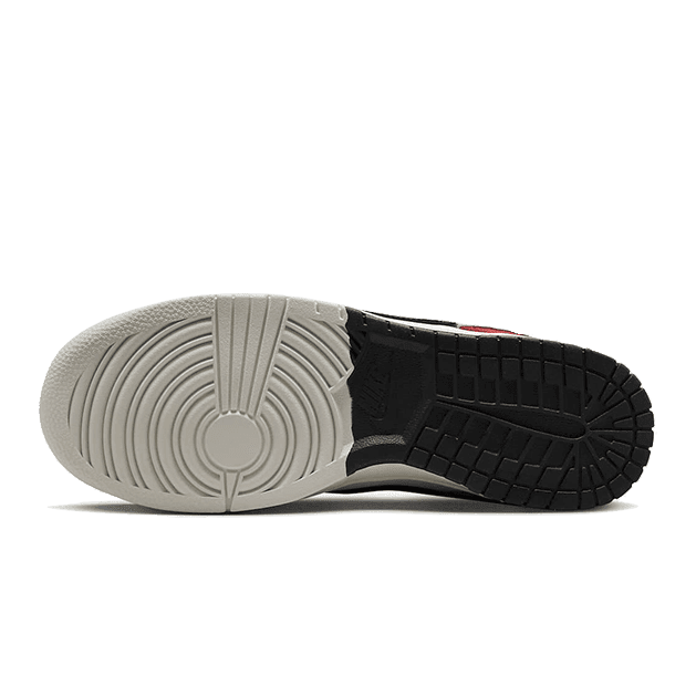 Zwart-witte Nike Dunk Low Chicago Split sneakers met een opvallend zoolontwerp op een groene achtergrond