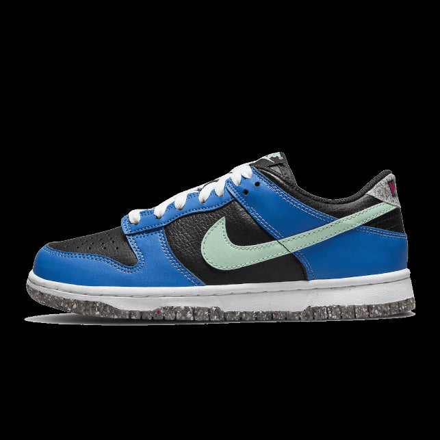 Blauwe Nike Dunk Low Crater Light Photo sneakers tegen een groene achtergrond