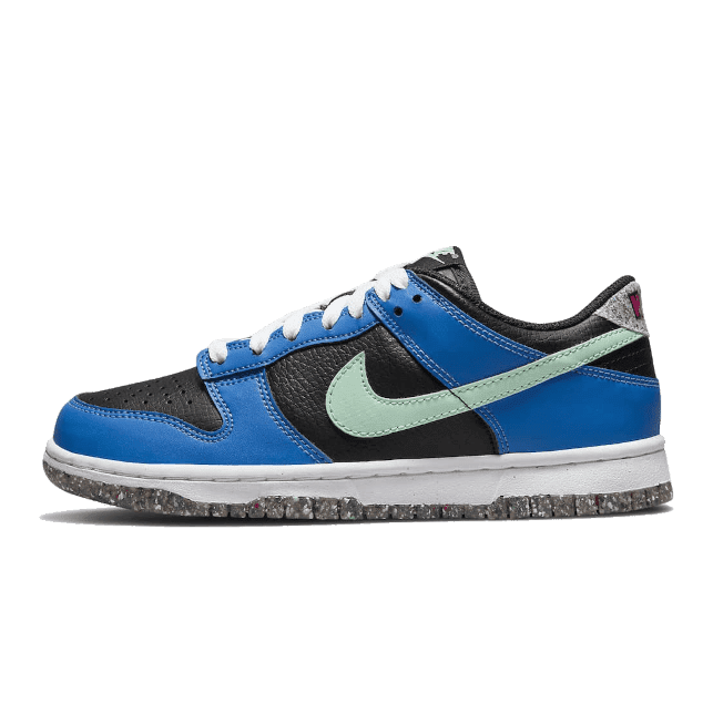 Blauwe Nike Dunk Low Crater Light Photo sneakers tegen een groene achtergrond