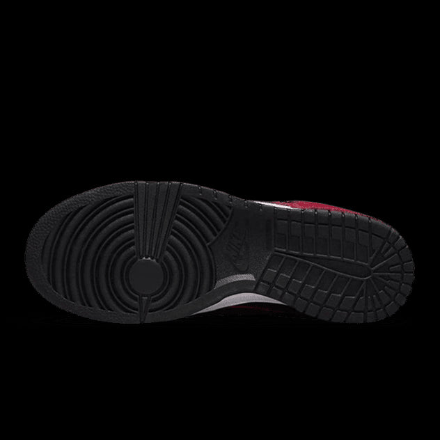 Zwart-rode Nike Dunk Low Disrupt 2 sneakers op groene achtergrond