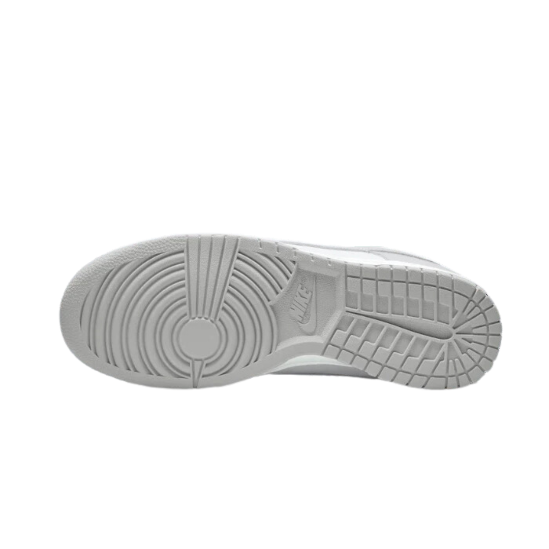 Grijze Nike Dunk Low sneakers met een gedetailleerd zoolpatroon op een witte achtergrond.