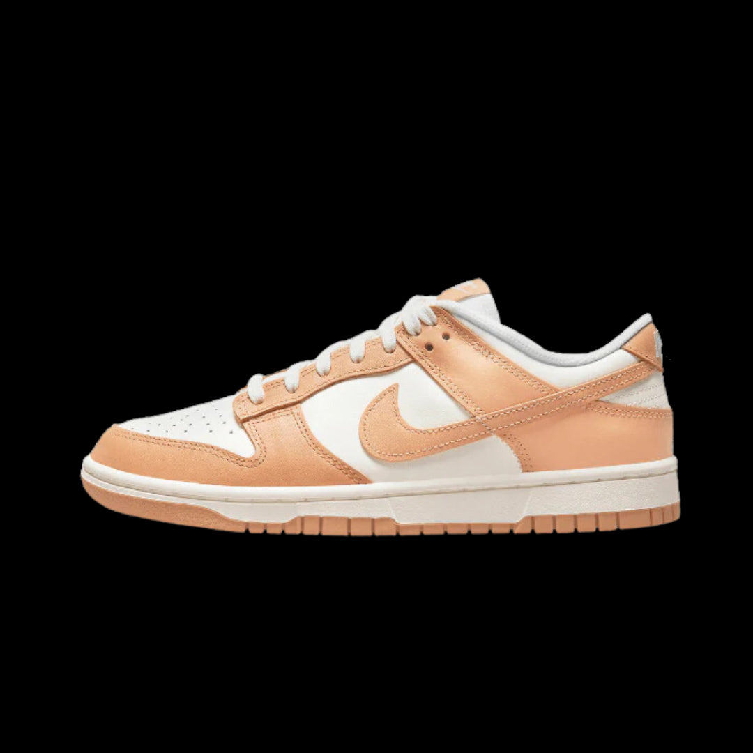 Stylish Nike Dunk Low Harvest Moon sneakers in a chic peach and white color scheme, showcasing the iconic Nike branding and signature low-top silhouette.