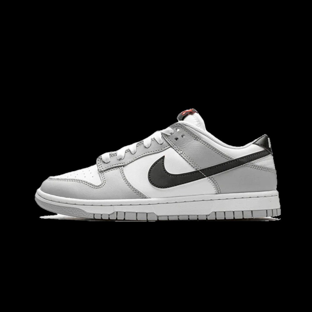 Grijze Nike Dunk Low sneakers met een witte zool en het iconische Nike-logo