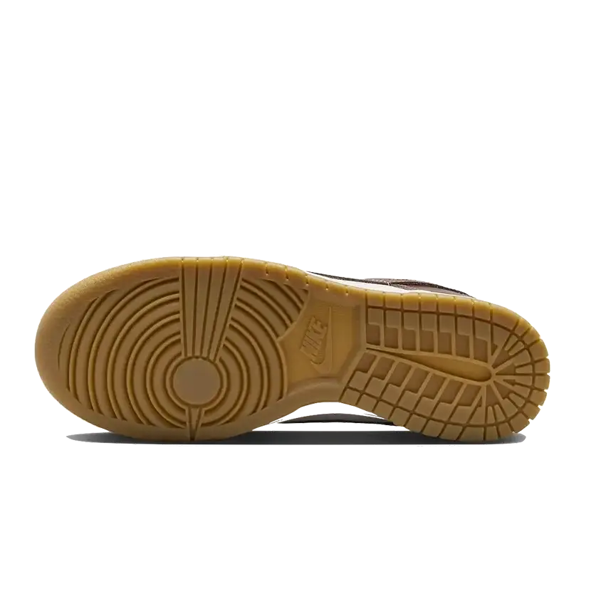 Donkere, roodbruine Nike Dunk Low LX sneakers met een klassieke zool. De sneakers hebben een robuuste, duurzame constructie met duidelijke groef- en textuurpatronen op de buitenzool.