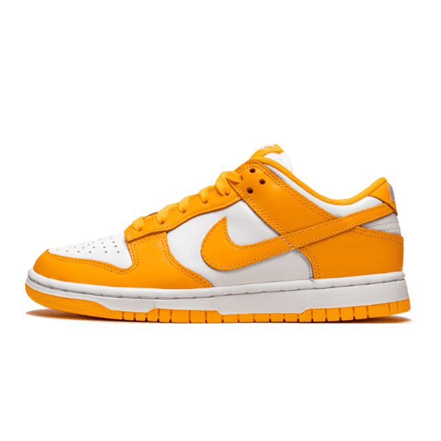 Oranje Nike Dunk Low sneakers met witte accenten op een groene achtergrond