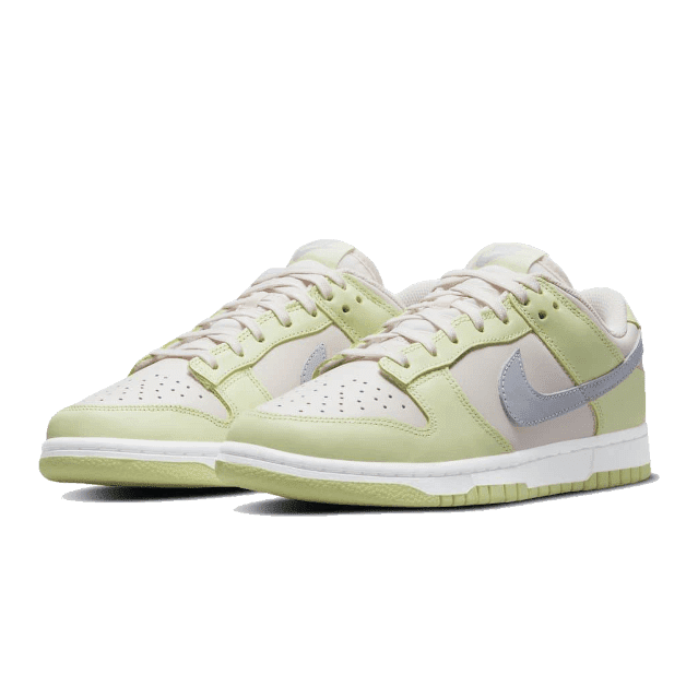 Laag Nike Dunk sneakers in ijsgroen kleur op een effen groene achtergrond. De schoenen hebben een klassiek en modern design met lichtgrijze accenten.