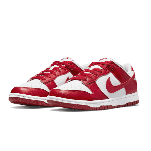 Robuuste Nike Dunk Low Next Nature Gym Red sneakers op groene achtergrond