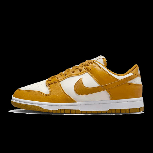Nike Dunk Low Next Nature Light Curry sneakers op groene achtergrond