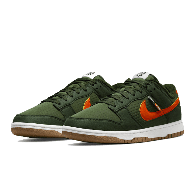 Groene Nike Dunk Low Next Nature sneakers met oranje accenten op een olijfgroene achtergrond