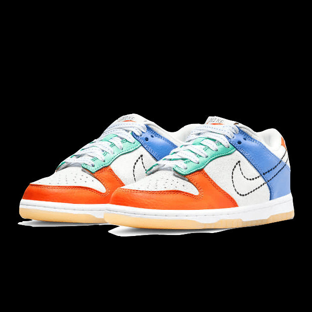 Opvallende Nike Dunk Low sneakers met kleurijke details. Het model heeft een witte, blauwe en oranje kleurstelling met contrasterende accenten. De sportieve sneakers zijn op een effen groene achtergrond gelegd, waardoor de verschillende kleuren en stijlvolle vormgeving goed tot hun recht komen.