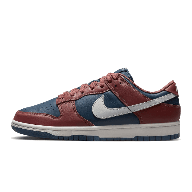 Nike Dunk Low Retro Canyon Rust - Exclusieve retro sneakers met een elegante kleurencombinatie van donkerblauw, rood en off-white op een groene achtergrond.