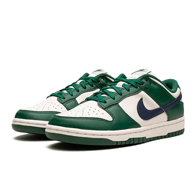 Retro Nike Dunk Low sneakers in groen en wit geplaatst op een groene achtergrond. De sneakers hebben leren details en een kenmerkende Nike-swoosh op de zijkant.