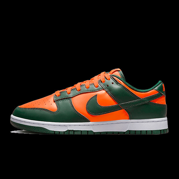 Oranje-groene Nike Dunk Low Retro Miami Hurricanes sneakers op een groene achtergrond