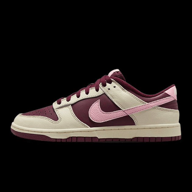 Elegante Nike Dunk Low Retro PRM Valentine's Day (2023) sneakers in paarsrode en roze accenten op een groene achtergrond.
