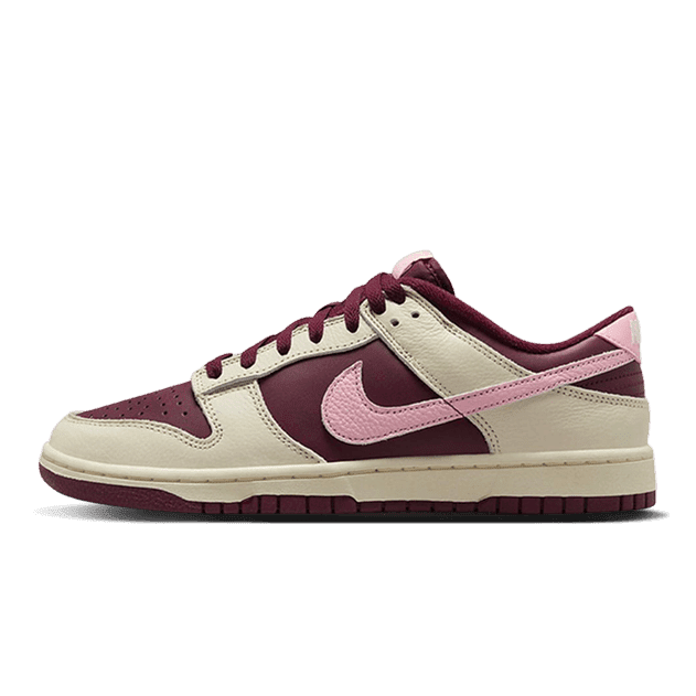 Elegante Nike Dunk Low Retro PRM Valentine's Day (2023) sneakers in paarsrode en roze accenten op een groene achtergrond.