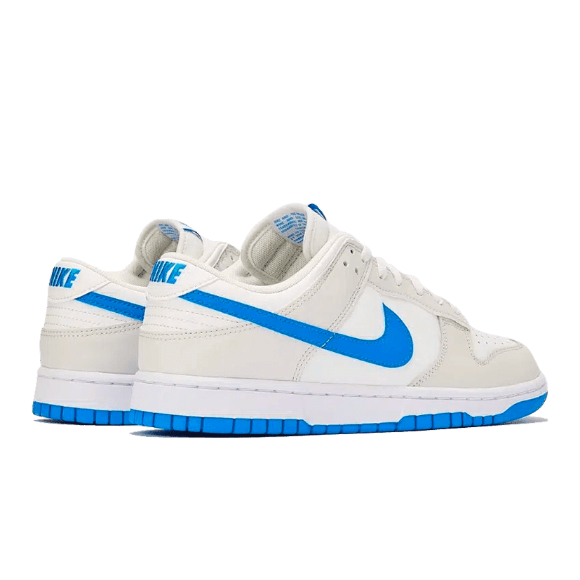 Moderne Nike Dunk Low Retro Photo Blue sneakers op groen oppervlak