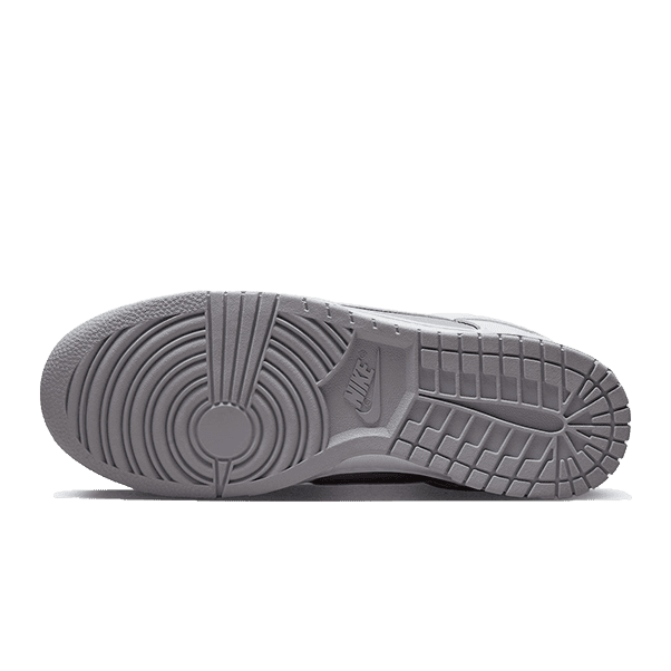 Nike Dunk Low Retro witte en grijze sneakers op een groene achtergrond