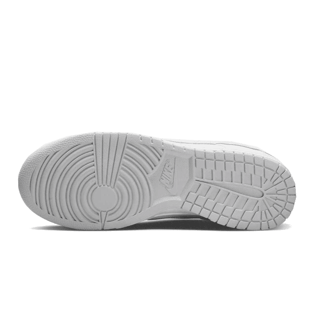 Witte Nike Dunk Low Retro sneakers met puur platina details op een groene achtergrond.