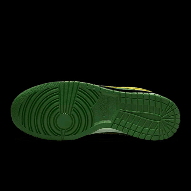 Groen met geel versierde Nike Dunk Low Reverse Brazil sneakers op groene achtergrond