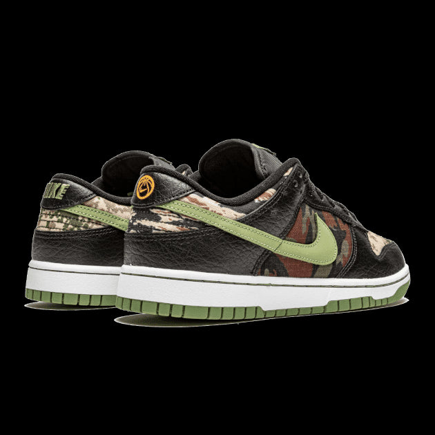 Exclusieve Nike Dunk Low SE sneakers met opvallend camouflagepatroon in contrasterende kleuren op een groene achtergrond.
