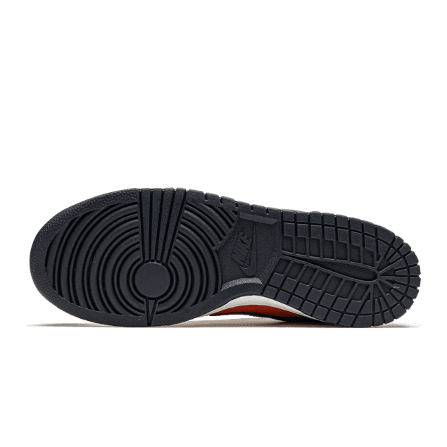 Zwarte Nike Dunk Low SP Champ Colors sneakers met geribbelde zool en opvallend rood/oranje accenten op een groene achtergrond