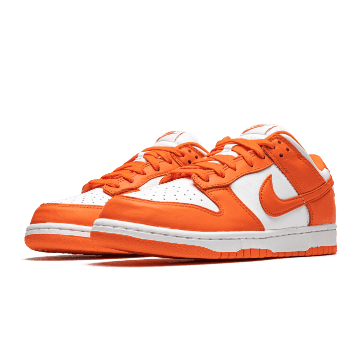 Oranje Dunk Low SP Nike sneakers tegen een groene achtergrond