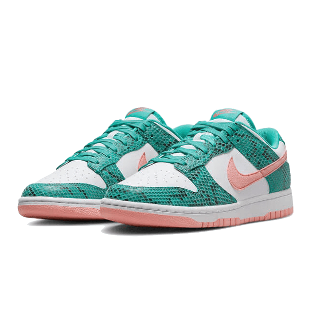 Sneakers Nike Dunk Low Snakeskin in gekleurde tinten van aquagroen en gebroken wit met roze accenten, geplaatst op een groen oppervlak.