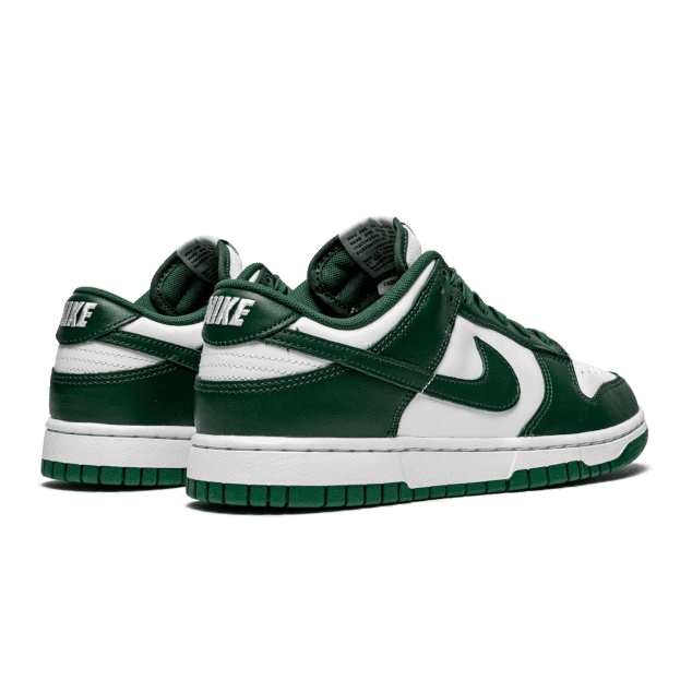 Stijlvolle Nike Dunk Low Spartan Green sneakers op een groene achtergrond. Deze klassieke sneakers hebben een opvallend groen-wit kleurenschema en een sterk, degelijk ontwerp.