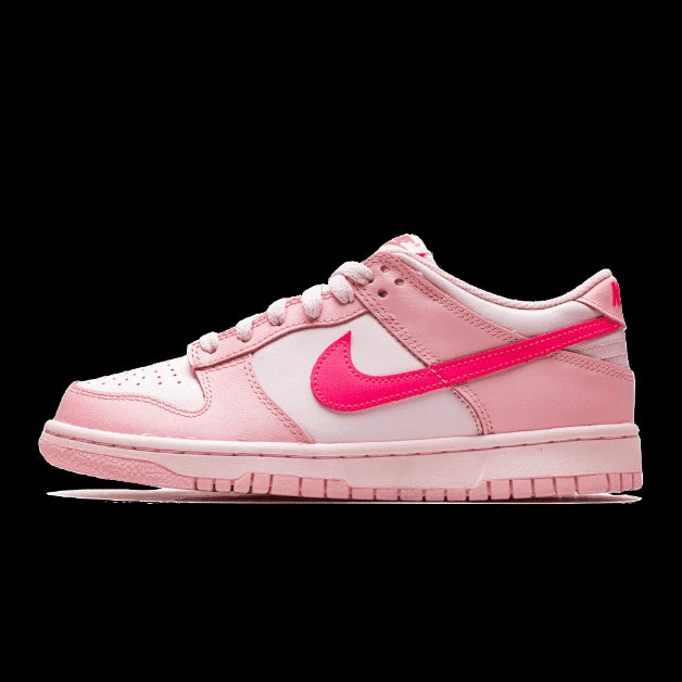 Roze Nike Dunk Low sneakers met roze details en Swoosh op een groene achtergrond