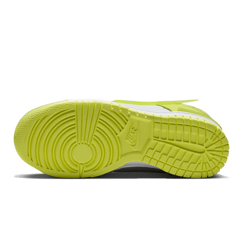 Neon gele Nike Dunk Low Twist Lemon Twist sneakers op een groene achtergrond. De zool heeft een opvallend, gestructureerd patroon en de bovenkant heeft een kleurrijk design.