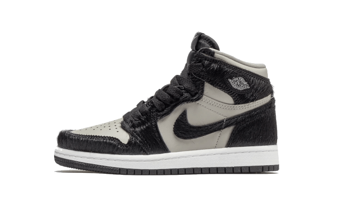 Zwarte en grijze Nike Air Jordan 1 Retro High OG Twist 2.0 Enfant (PS) sneakers, geplaatst op een effen, donkergroene achtergrond.