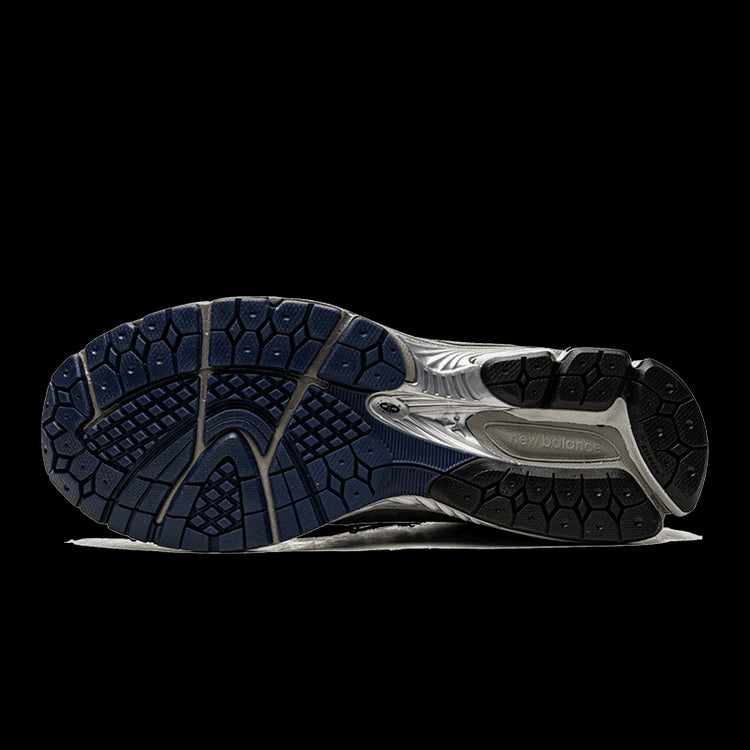 Grijze en indigo sportieve New Balance 1906R sneakers met een uitgebreid loopbandpatroon voor optimale grip en stabiliteit.